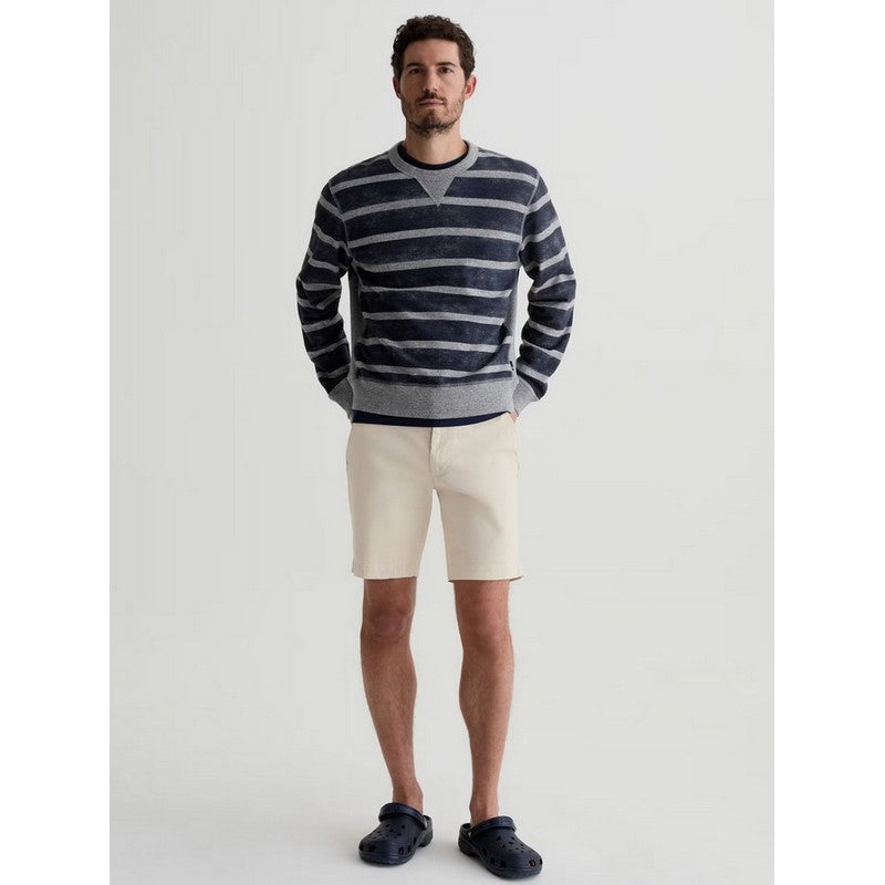 Man wearing a striped sweater and shorts on a plain background