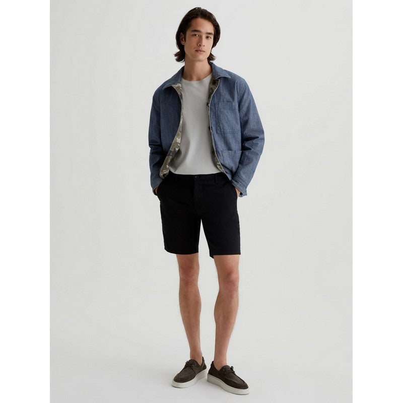 Man wearing a denim jacket, white t-shirt, black shorts, and brown shoes on a white background