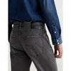 Close-up back view of a person wearing dark gray washed denim jeans and a blue denim shirt, showing the back pocket and waistband.