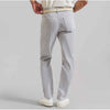 Light gray pants worn by a person on a plain background