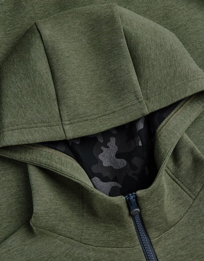 Close-up of an olive green zip-up hoodie with a black and gray camouflage pattern lining visible inside the open hood.