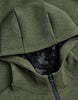 Close-up of an olive green zip-up hoodie with a black and gray camouflage pattern lining visible inside the open hood.