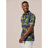 Man wearing a blue floral shirt against a beige background