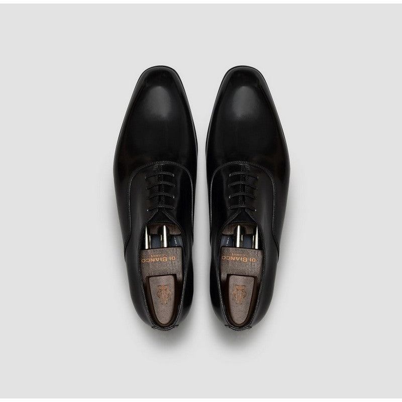Pair of black dress shoes on a light gray background