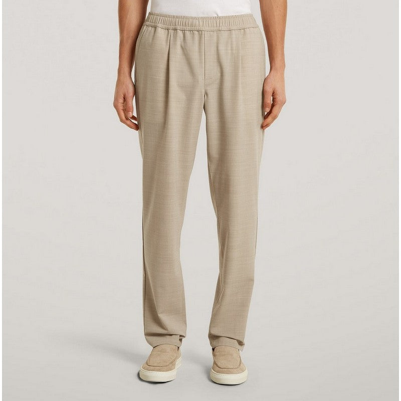 Beige pants worn by a person on a plain background