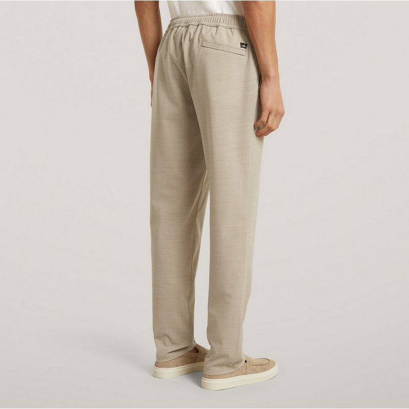 Beige pants worn by a person on a light gray background