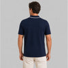 Man wearing a navy blue polo shirt on a gray background