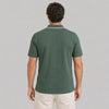 Man wearing a green polo shirt on a gray background