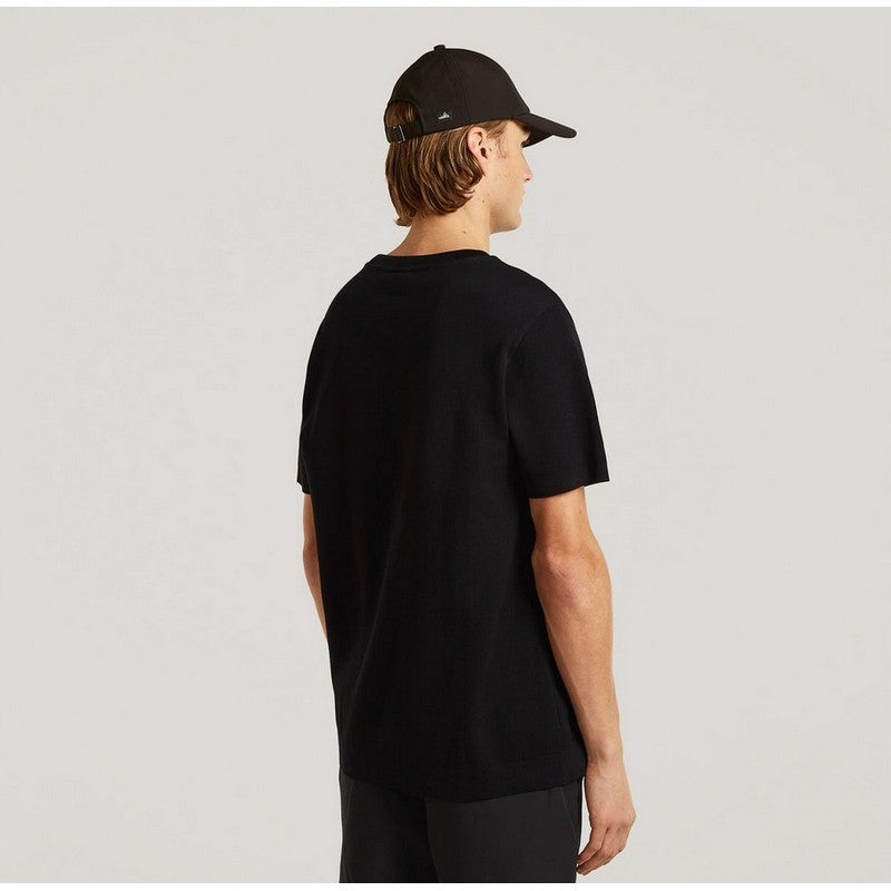 Person wearing a black t-shirt and cap on a light gray background