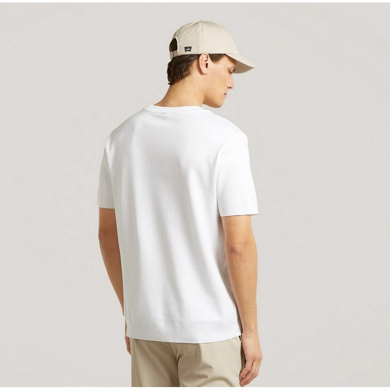Person wearing a white t-shirt and beige cap on a plain background