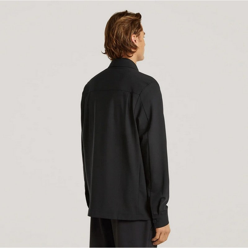 Person wearing a black shirt from behind on a light gray background