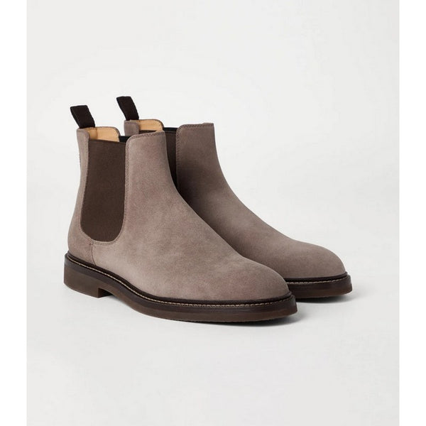 Pair of brown suede Chelsea boots on a light gray background