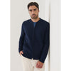 Man wearing a navy blue zip-up sweater against a white background