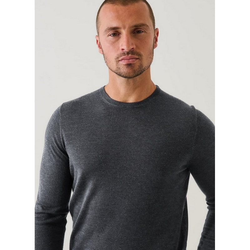 Man wearing a dark gray long-sleeve shirt against a plain background
