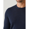 Navy blue sweater worn by a person on a light gray background