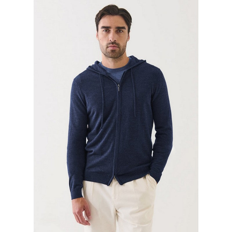 Man wearing a navy blue zip-up hoodie against a white background