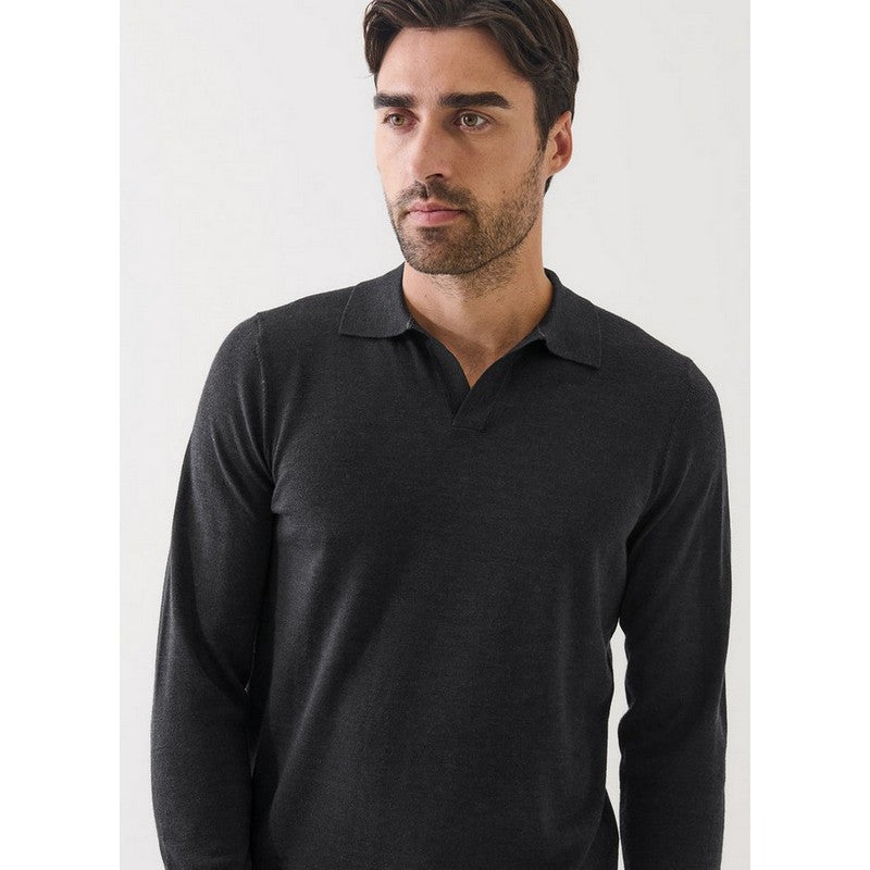 Man wearing a black long-sleeve polo shirt against a white background
