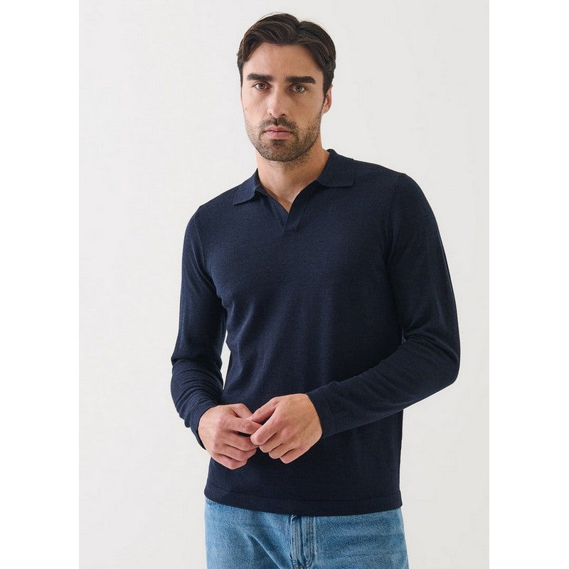 Man wearing a navy long-sleeve polo shirt against a white background