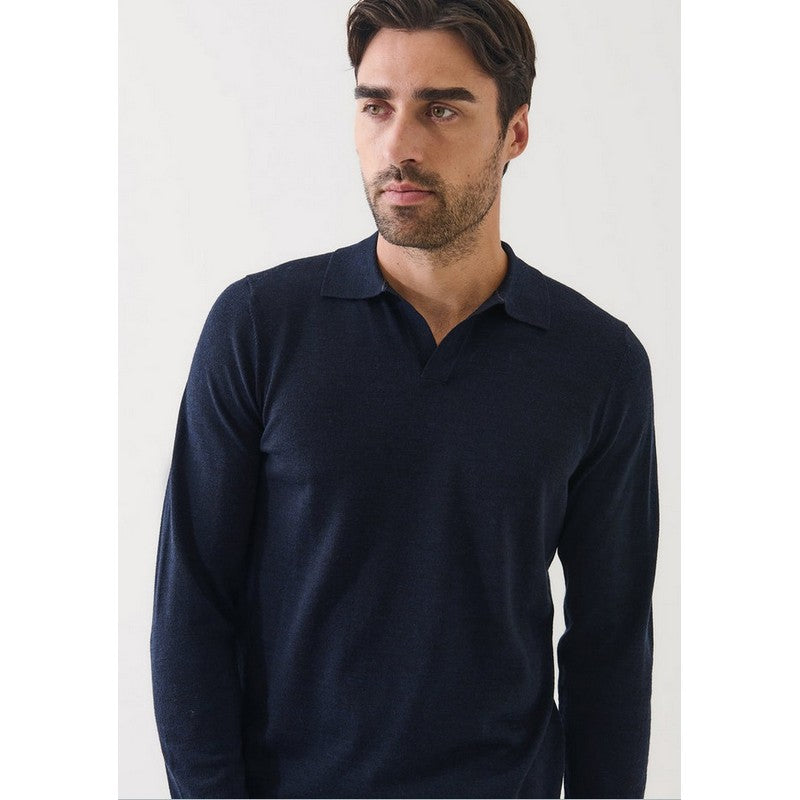 Man wearing a navy long-sleeve polo shirt against a white background