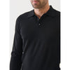 Man wearing a black long-sleeve polo shirt against a white background