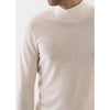 Beige sweater worn by a person on a white background