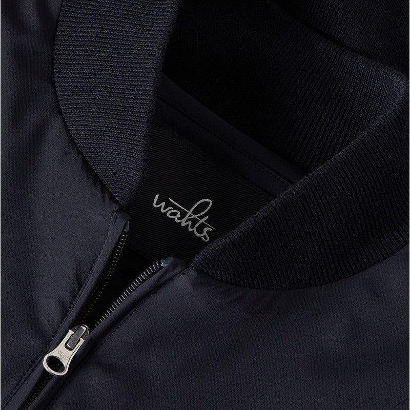 Close-up of a black jacket with a brand logo on the collar.