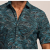 Close-up of a person wearing a blue patterned shirt with whale design.