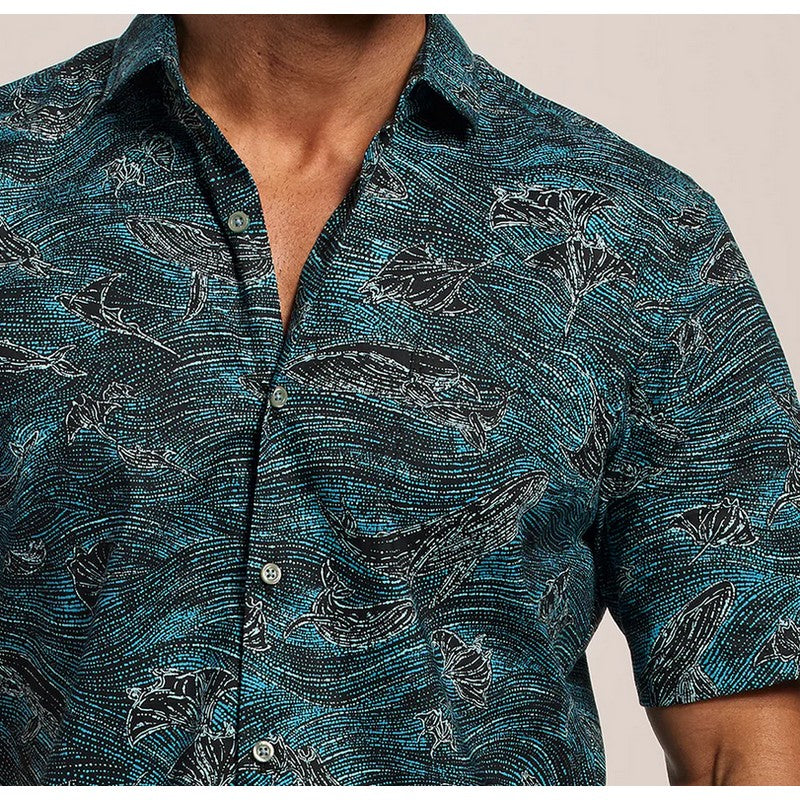 Close-up of a person wearing a blue patterned shirt with whale design.