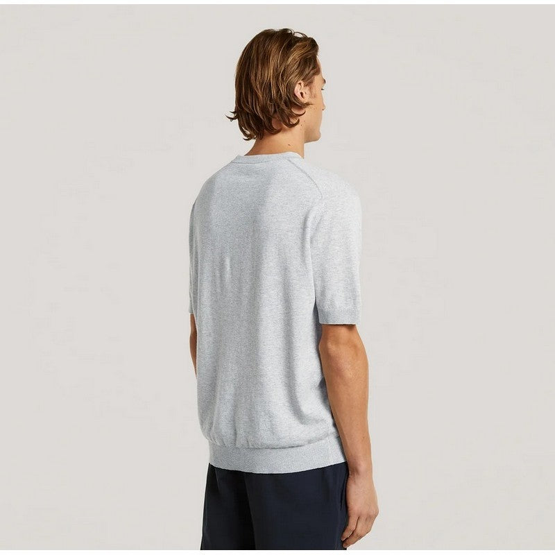 Man wearing a light gray t-shirt and dark shorts on a plain background