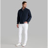 Man wearing a navy jacket and white pants on a gray background