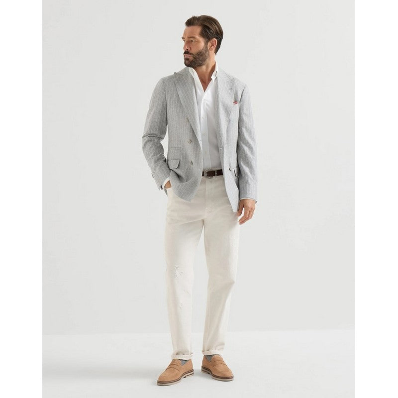 A man modeling a light gray pinstriped blazer, white dress shirt, off-white trousers, and tan loafers against a plain white studio background.