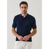 Man wearing a navy blue textured polo shirt against a light gray background