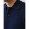 Navy blue textured polo shirt with collar and buttons on a plain background