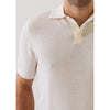 Man wearing a textured beige polo shirt with a plain background