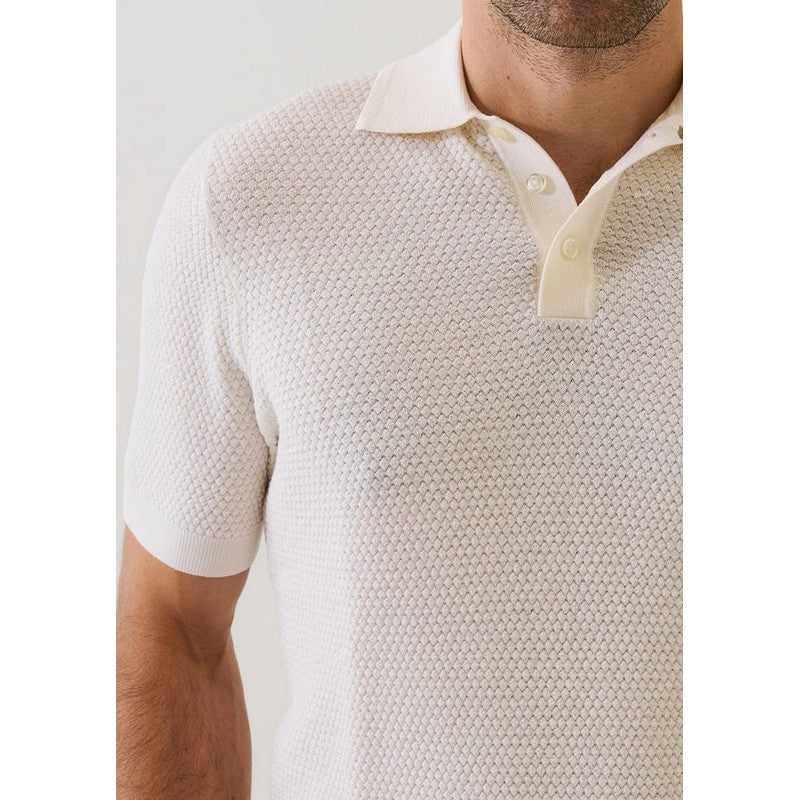 Man wearing a textured beige polo shirt with a plain background