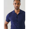 Man wearing a navy blue textured shirt against a plain background