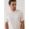 Man wearing a plain white t-shirt against a light gray background