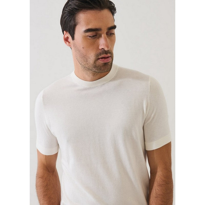 Man wearing a plain white t-shirt against a light gray background