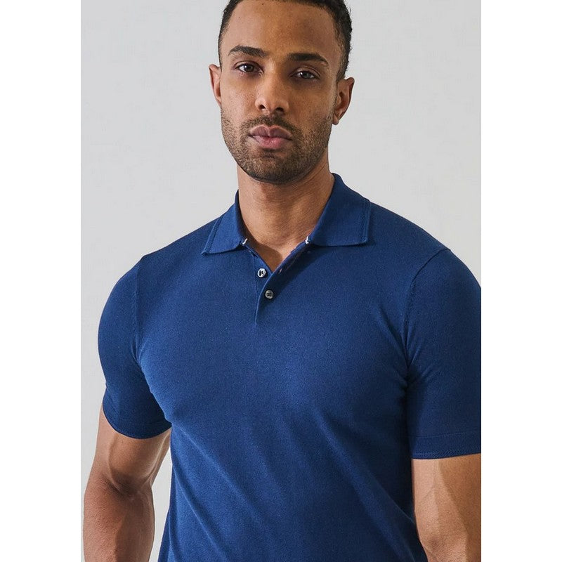 Man wearing a blue polo shirt against a plain background