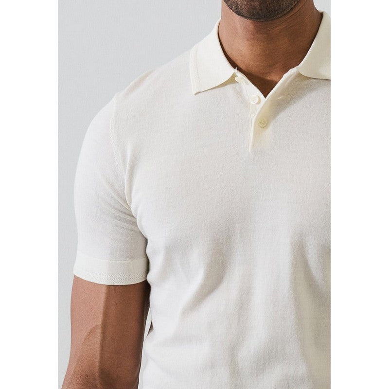 Man wearing a white polo shirt against a light gray background
