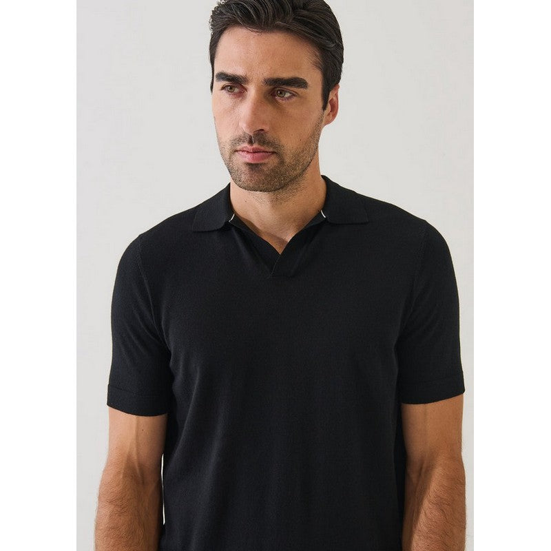 Man wearing a black polo shirt against a plain background