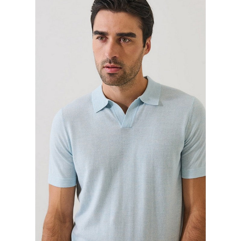 Man wearing a light blue polo shirt against a plain background
